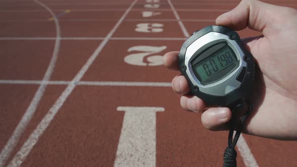 Male Hand Turning on Stopwatch to Record Time During Sport Competition, Deadline