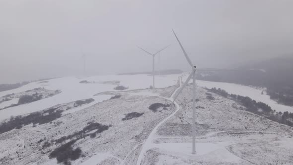 Aerial View of a Wind Farm in Winter Rotating Turbines on a Snowy Field in Ukraine