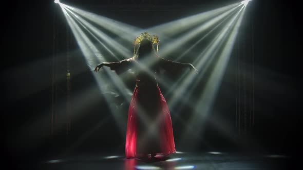 The Attractive Actress Performs Flowing Hand Movements and Dances. A Bright Brunette in a Red Silk