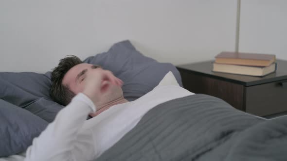 Man Having Headache While Sleeping in Bed