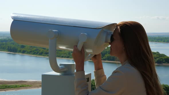 Young Woman Looking Through Big Street Binoculars