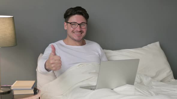 Thumbs Up Sign By Middle Aged Man with Laptop in Bed