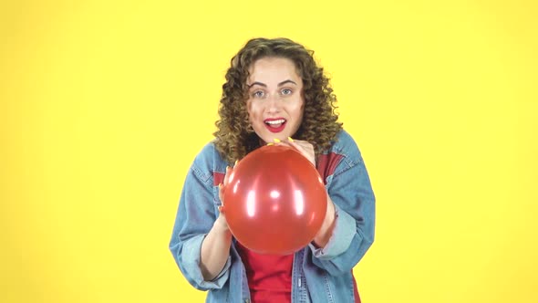 The Girl Inflates a Red Balloon, Takes in Hand and Releases, the Ball Is Blown Away and Flies Away