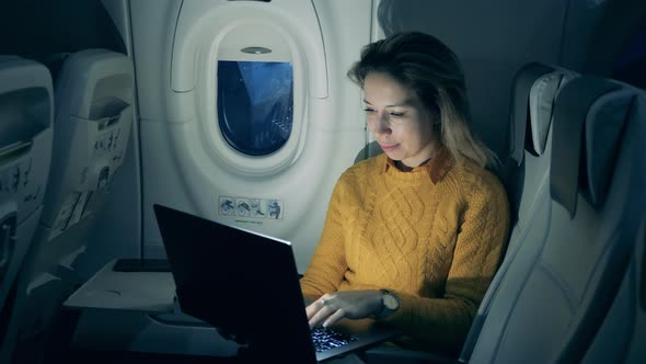 Aircraft Flight and a Cheerful Woman Typing on a Laptop in the Span of It