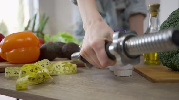 Healthful Vegetarian Vegetables and Measuring Tape on Table with Female Caucasian Hand Putting