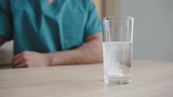 Unknown Arabian Man Patient Care Medical Worker Throwing Effervescent Tablet in Glass Water Vitamin