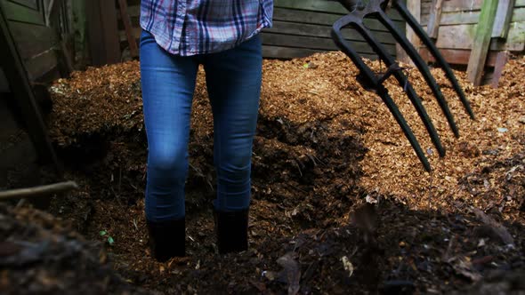 Mature woman using gardening fork in the garden