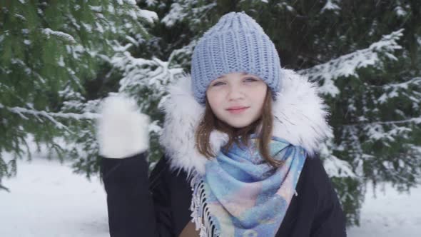 Portrait of a Happy Blueeyed Teenage Girl in a Snowy Park