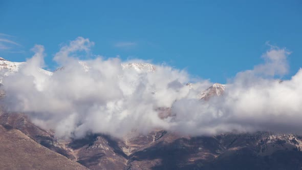 Time lapse of snowy mountain top as clouds move