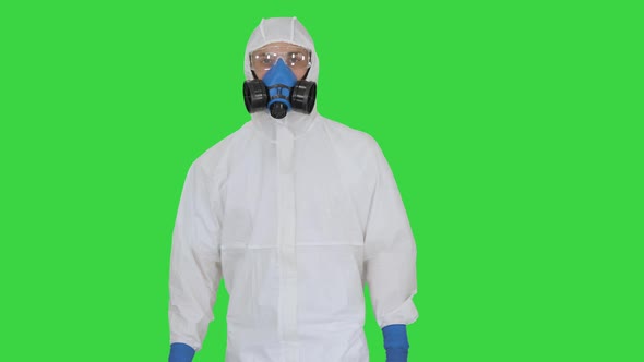 Virologist Man in Protective Costume Checking the Situation on a Green Screen, Chroma Key.