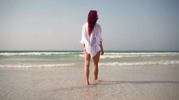 Lonely Slim Woman Walks Along an Empty Seashore