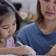Close up shot Little Asian girl with mother doing homework in the bed room - VideoHive Item for Sale