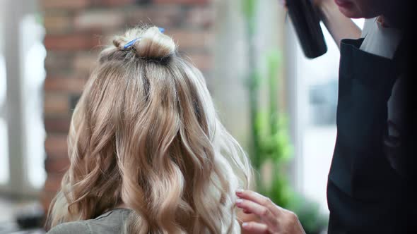 Closeup Hands of Woman Hairdresser Fixing Curly Hairstyle Use Hair Spray