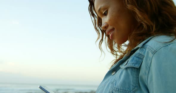 Woman using mobile phone on beach