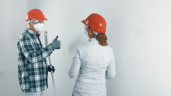 An Elderly Married Couple a Man with a Beard and a Woman in Protective Masks and Helmets are