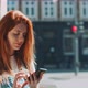 Young woman smiling and using a smartphone in the street - VideoHive Item for Sale