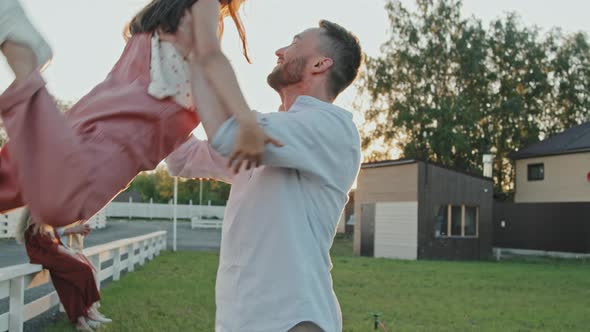 Dad Circling Daughter in Arms Outside