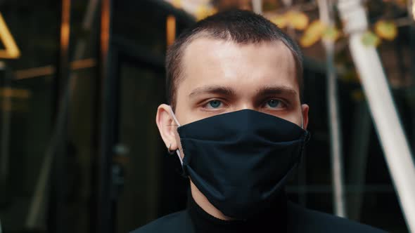 Portrait Man Wearing Protective Face Mask Looks at Camera COVID-19 Coronavirus Infection Pandemic