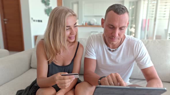 Couple Using a Tablet and Sitting on the Couch