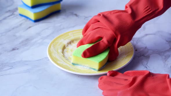 Sponge  Rubber Gloves and Colorful Plate on Blue