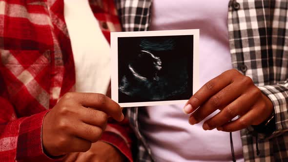 African American Two Happy Future Mothers Sonogram Image at Home in Evening