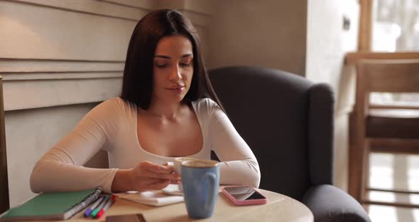 Woman Drinking Coffee in Cafe