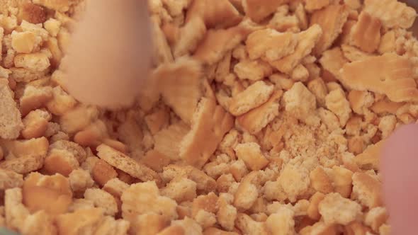 Cookies Are Crushed Into Crumbs in a Glass Bowl with a Pestle - Closeup