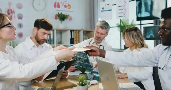 Men and Women-Doctors Working Together with Reports and Results of Patient's X-ray scan