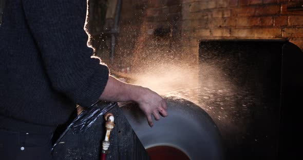 Bladesmith wet grinding a blade