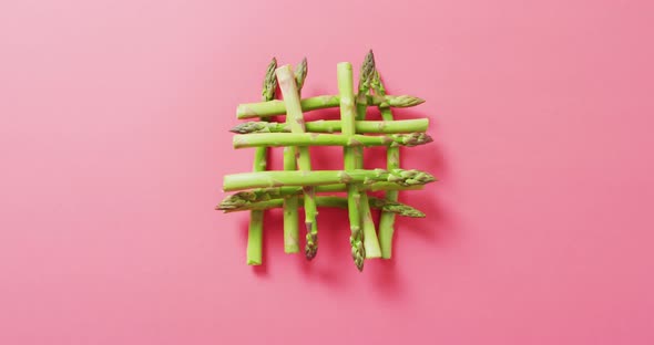 Video of fresh asparagus over pink background