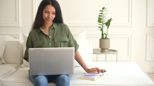 Serious Indian Female Student Using Laptop for Watching Webinars