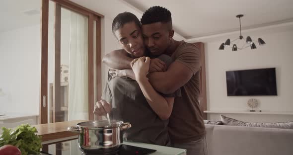 Couple Hugging and Talking During Lunch Preparation