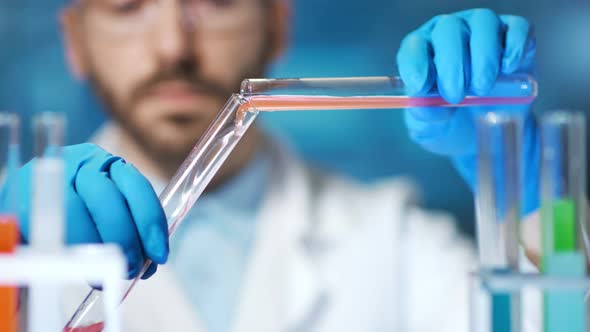 Closeup Hands of Professional Chemist Pouring Liquid Reactive Using Beaker in Laboratory