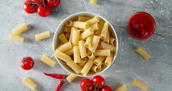 Dry Cannelloni Pasta with Cherry Tomatoes Slowly Rotates. 