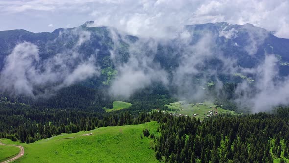 Scenic Aerial View Of Fog And Clouds Rising From Woodlands In Mountain Valley