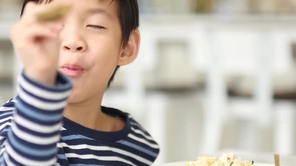 Cute Asian Child Eating Breakfast In A Restaurant 