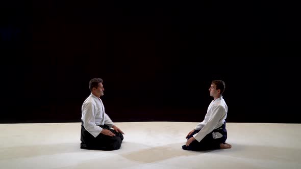 Two Masters Martial Arts Aikido Bow To Each Other. Shot Isolated on Black and White Background