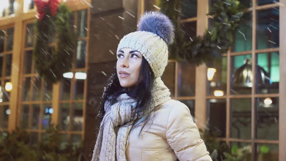 Positive Girl Looking Up on Snow Near Coffee House.