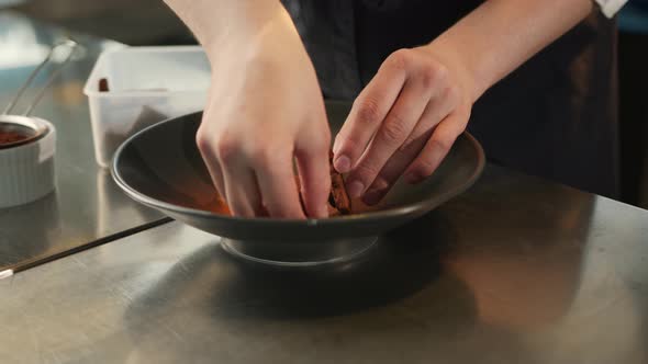 Close-up of professional kitchen: brownies are decorated with broken chocolate