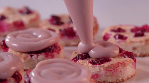 Pastry Chef Squeezes Pink Cream From a Pastry Bag Onto the Mini Cake