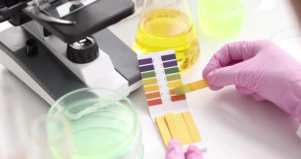 Chemist in Lab Checking with Ph Strips Closeup