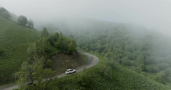 Scenic View Of A Car Traveling Across Tskhratskaro Pass During Foggy Day In Georgia. Aerial Drone Sh