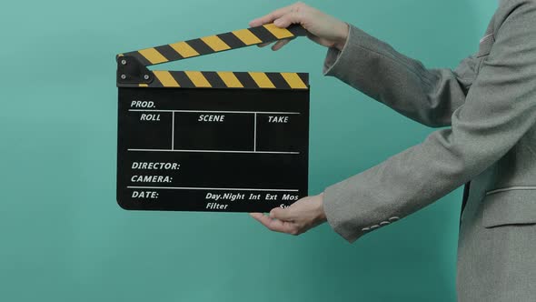 Movie slate or clapperboard hitting. Business woman holding empty film slate and clapping it.