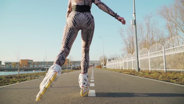 Athletic Slim Rides Girl Roller Skating and happily raises his hands