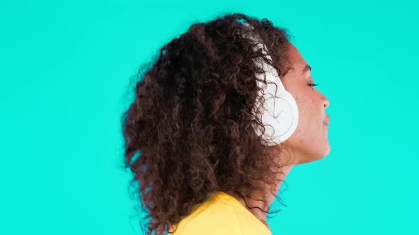 Mixed Race Woman Dancing with Wireless Headphones on Teal Background