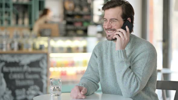 Young Man Talking Smartphone Cafe