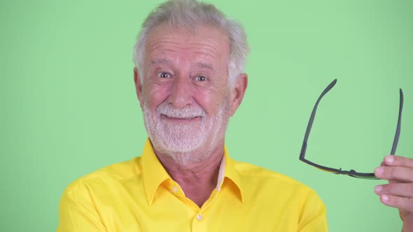 Face of Happy Senior Bearded Businessman Smiling and Removing Sunglasses