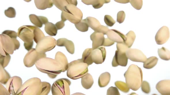 Closeup of Salted Pistachios Flying on a White Background