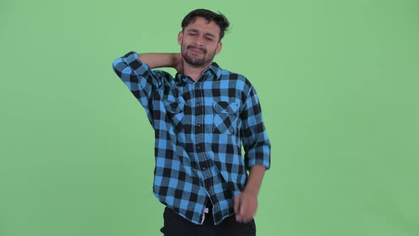 Stressed Young Bearded Persian Hipster Man Having Neck Pain