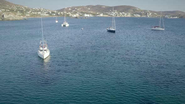 Aerial view of sailboats sailing cross blue and clean sea in Greece.